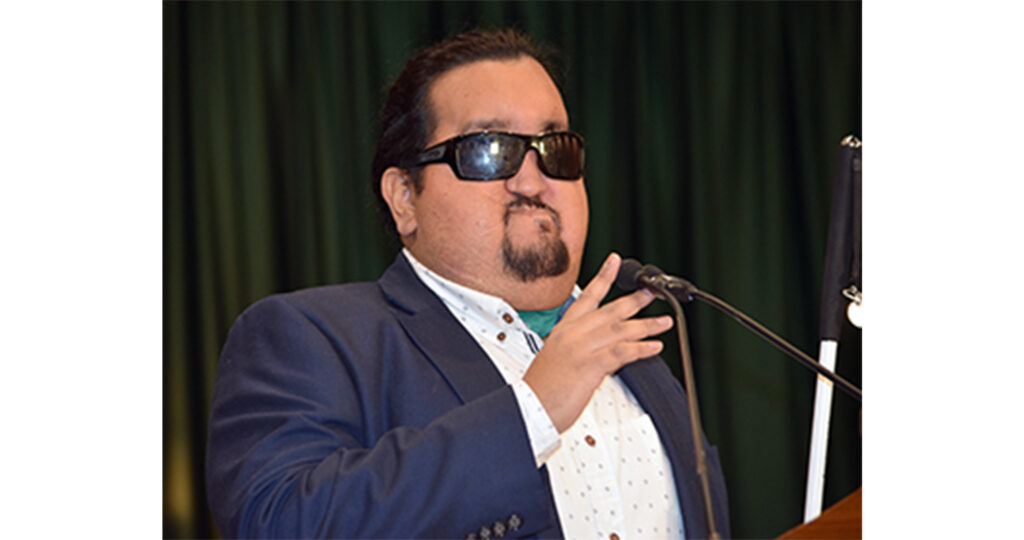 Photo of Daniel Martinez speaking at the microphone. 