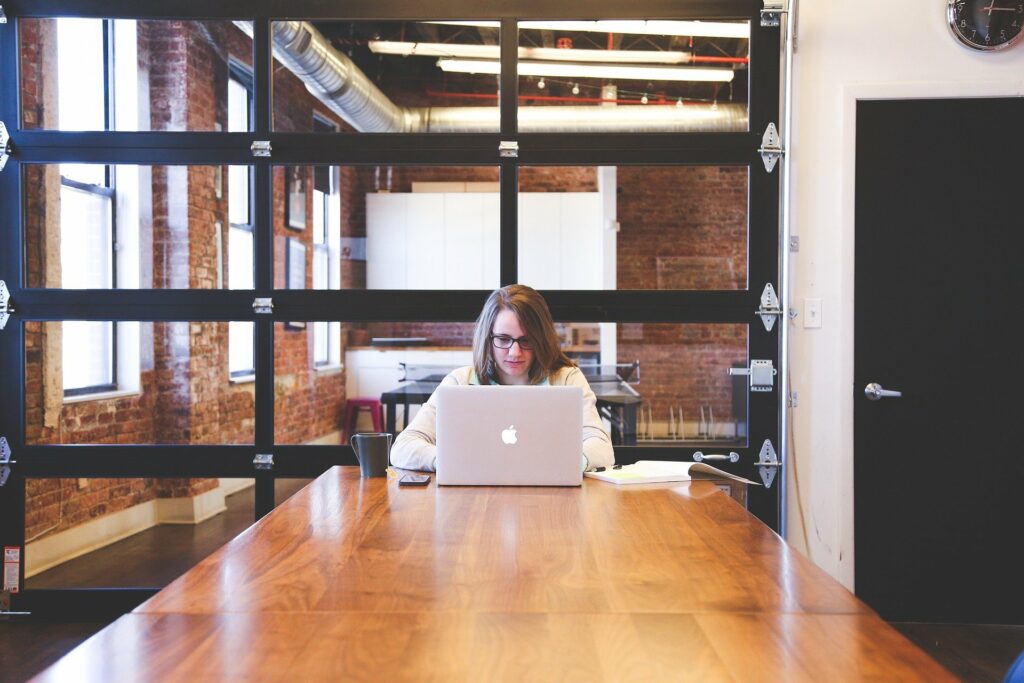 Individual at table working on a laptop